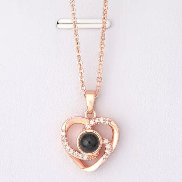 A nano-microcarved heart pendant with a central crystal and surrounding diamonds, reflecting | Feelsosweat